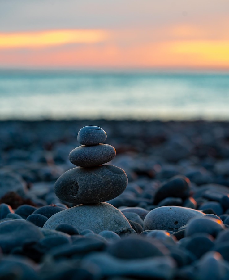 Foto pirámide de piedras en el fondo del mar y puesta de sol