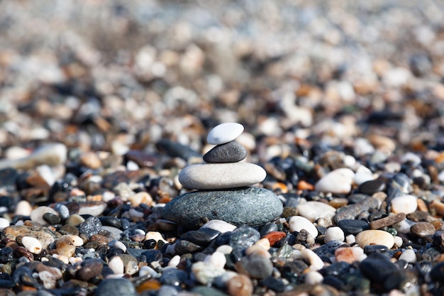 Pirámide de piedras marinas Piedras de diferentes formas, tamaños y colores en el primer plano de la orilla del mar