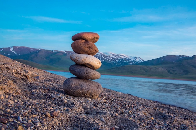 Pirámide de piedras en la orilla del mar al atardecer