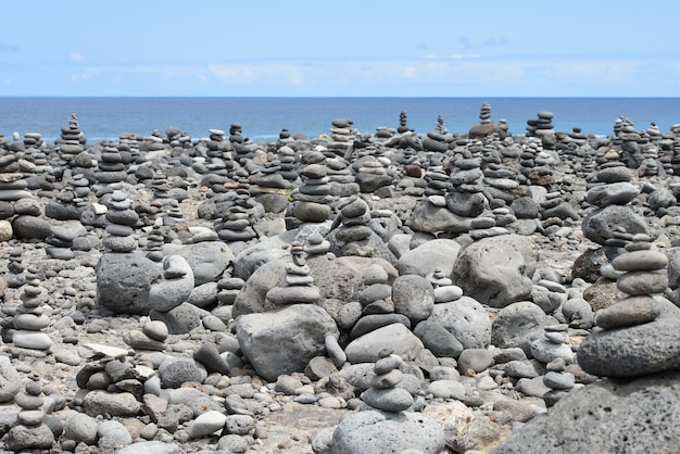 Pirámide de piedras redondas apiladas en la orilla del mar, concepto de equilibrio