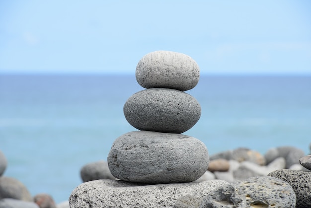 Pirámide de piedras redondas apiladas en la orilla del mar, concepto de equilibrio