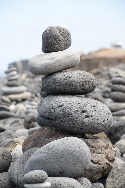 Pirámide de piedras redondas apiladas en la orilla del mar, concepto de equilibrio