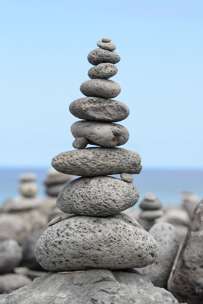 Pirámide de piedras redondas apiladas en la orilla del mar, concepto de equilibrio