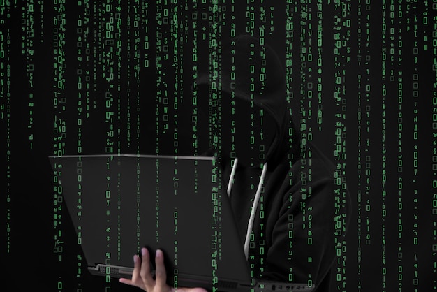 Pirata informático asiático en capucha negra con fondo de matriz