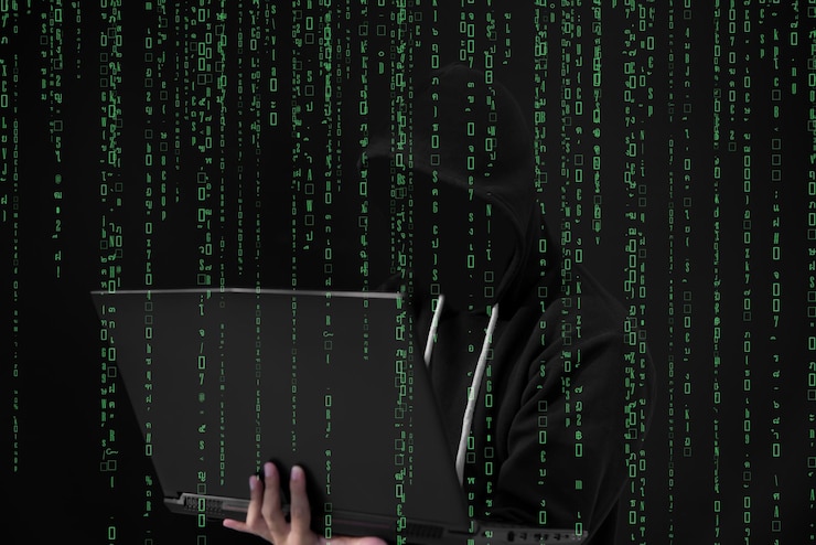 Foto pirata informático asiático en capucha negra con fondo de matriz