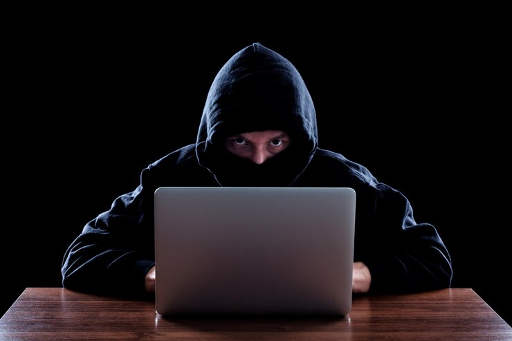 Foto pirata informático encapuchado robando información