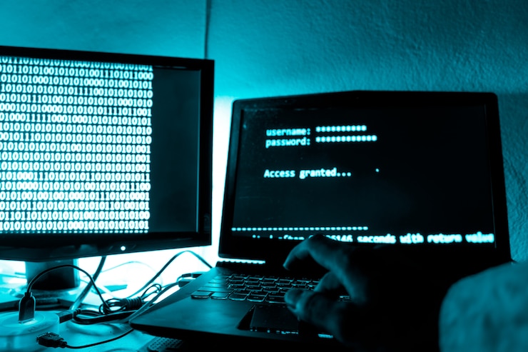 Foto el pirata informático imprime un código en el teclado de una computadora portátil para ingresar a un sistema de organización secreto.