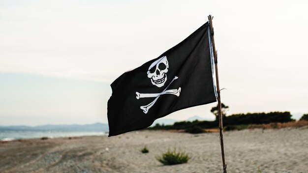 Foto piratas tejiendo banderas en la playa