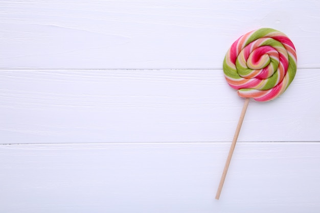 Foto piruleta de colores sobre fondo blanco de madera, dulces