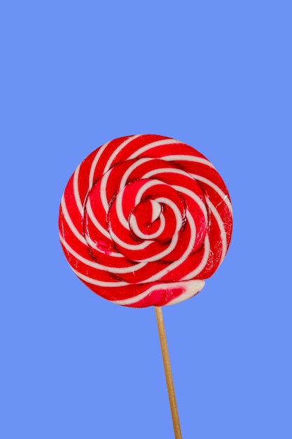 Piruleta dulce rojo sobre fondo azul.