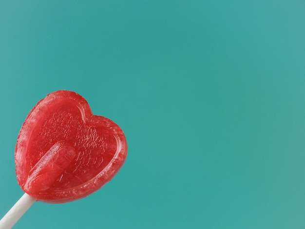 Una piruleta en forma de corazón con un corazón rojo en el medio.