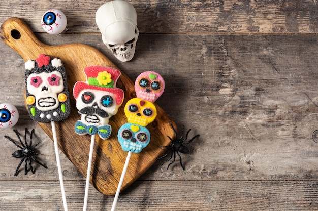 Piruletas de calavera de caramelo en la mesa de madera rústica