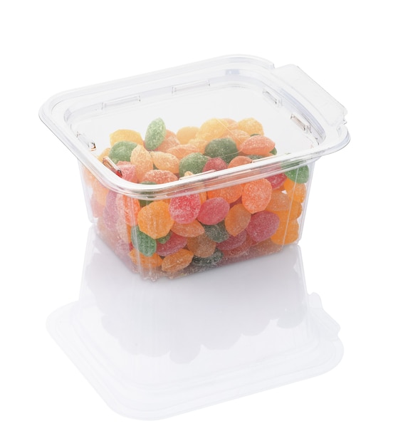 Piruletas de caramelo de colores en un recipiente de plástico transparente aislado en blanco con trazado de recorte