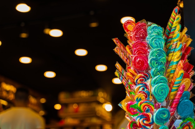 Foto piruletas de color caramelo para niños en palos a la entrada del mercado.