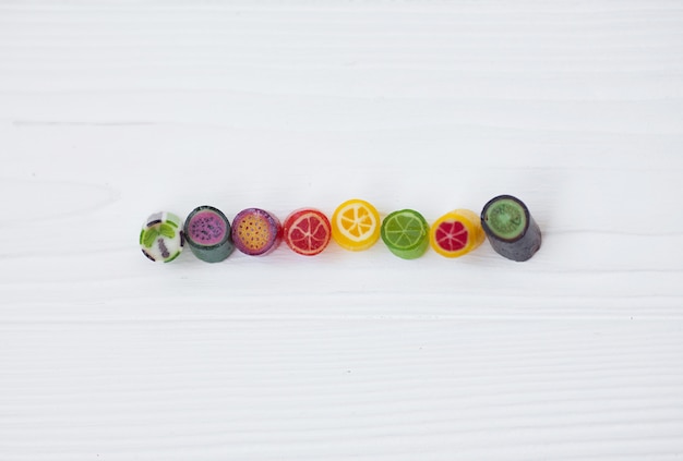 Piruletas de colores, bastones de caramelo y dulces dulces se mezclan sobre fondo de madera