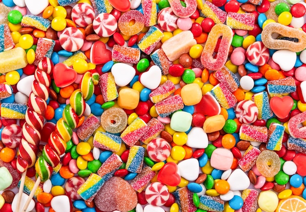 Foto piruletas de colores y caramelos redondos de diferentes colores vista superior