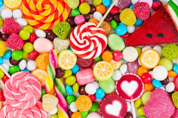 Foto piruletas de colores y caramelos redondos de diferentes colores vista superior