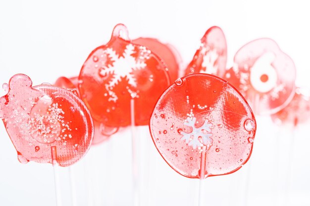 Pirulitos caseiros de sabor de baga com flocos de neve em um pirulito branco.