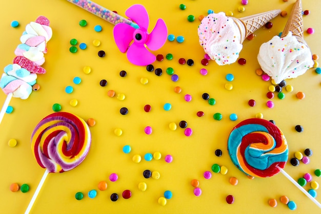 Foto pirulitos e doces coloridos para crianças em um fundo amarelo
