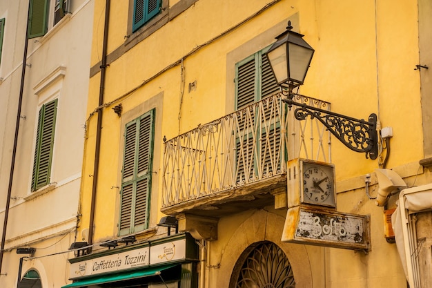 Pisa Italia 20 de julio de 2013 Fragmento de una calle con un letrero reloj retro balcón y linterna en Pisa
