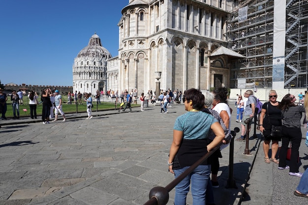 Foto pisa, italia - 26 de septiembre de 2017 - turista tomando fotografías en la famosa torre inclinada