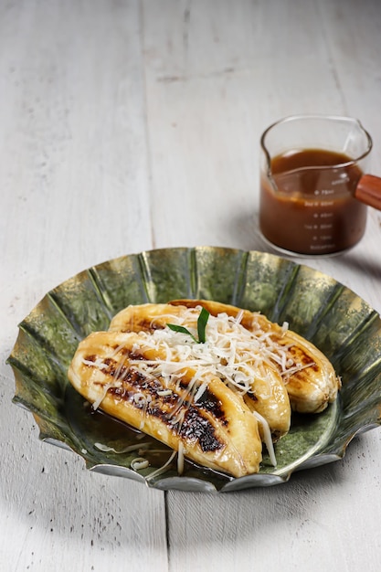 Pisang Gapit o pisang Epe es plátano a la parrilla con salsa de azúcar moreno de coco y cubierta con queso