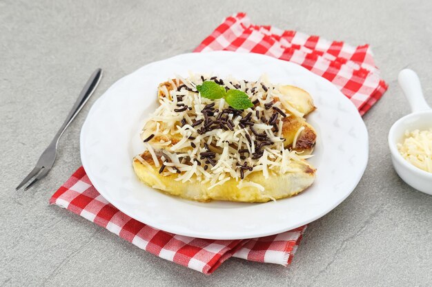 Pisang panggang Gegrillte Banane mit Schokoladenstreuseln, geriebenem Käse und süßer weißer Milch