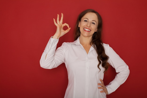 Piscando o modelo feminino jovem bonita mulher bonita jovem com cabelos morenos na camisa branca