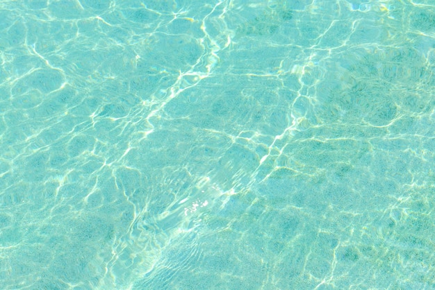 Piscina de agua azul con un efecto de reflejo de olas y luz solar