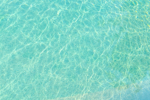 Piscina de agua azul con un efecto de reflejo de olas y luz solar