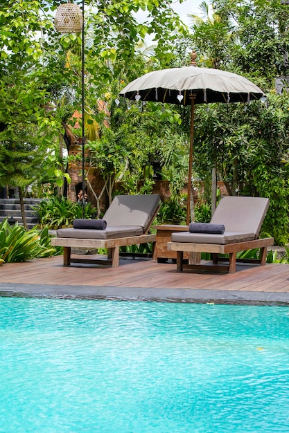 Foto piscina água azul folhas verdes de árvores e cadeiras de terraço no jardim tropical ilha de bali ubud indonésia