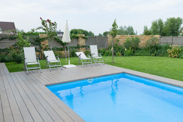 Piscina al aire libre en residencia privada, césped, jardín.