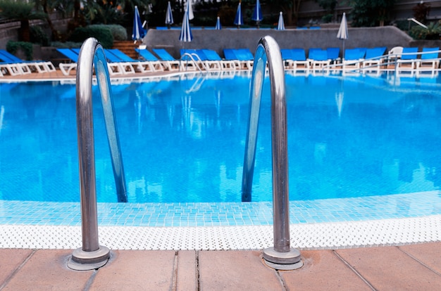 Piscina ao ar livre com escada no hotel. Relaxe e conceito de férias.