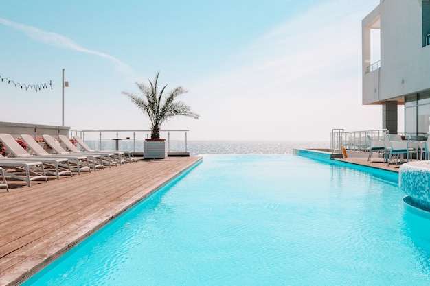 Piscina ao ar livre de verão e espreguiçadeiras. no hotel para descansar.