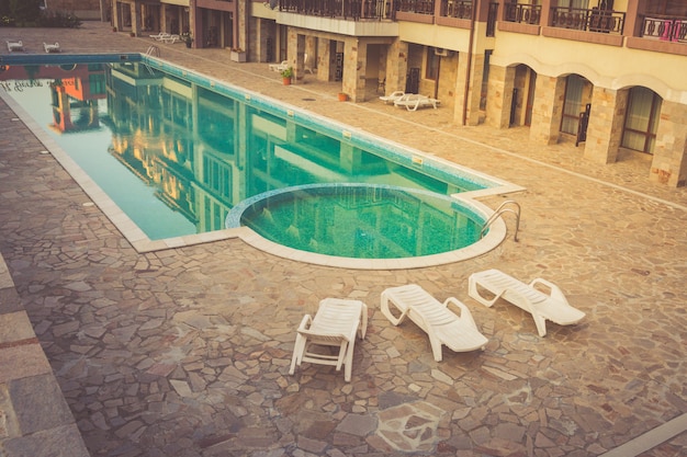 Piscina con chaise lounge en el resort en las noches de verano