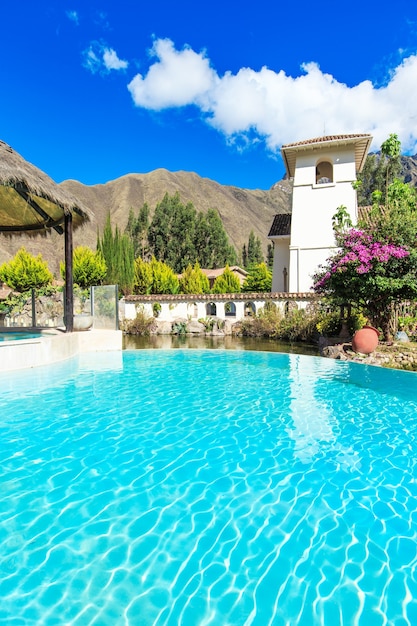 Piscina con cocotero y sombrilla blanca