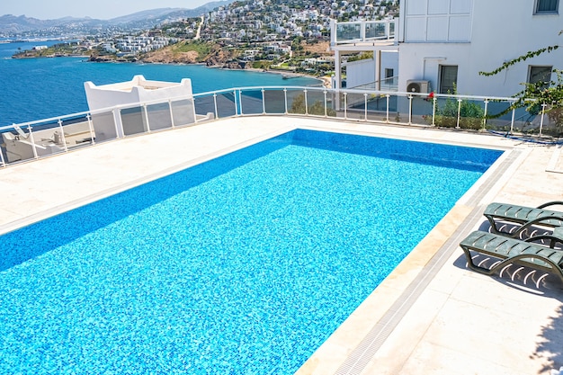 Piscina com água de cor turquesa no hotel ou aldeia de férias em dia de sol.