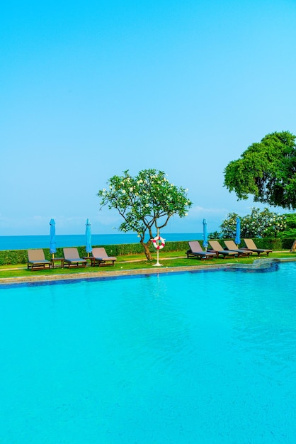 Piscina de cadeiras ou piscina de cama e guarda-chuva ao redor da piscina com fundo do mar