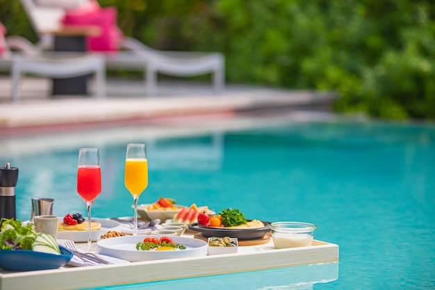 Piscina de desayuno, desayuno flotante en un lujoso resort tropical. Mesa relajante aguas tranquilas