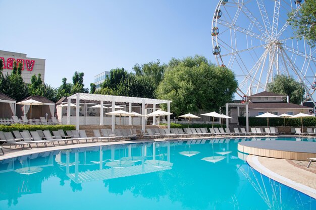 Piscina e cadeira branca com espreguiçadeiras brancas na praia Espreguiçadeiras de luxo