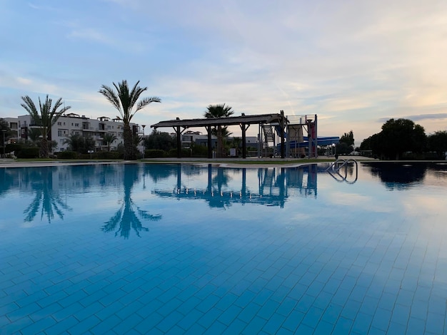 Foto una piscina con un edificio en la noche de fondo