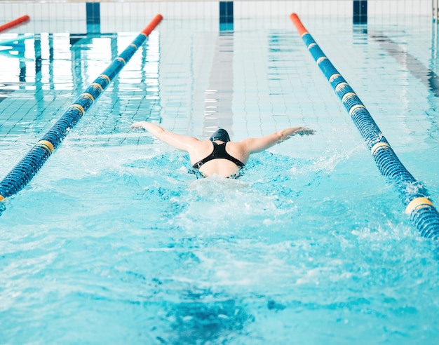 Piscina esportiva e atleta feminina treinando para uma competição de corrida ou torneio Treino de fitness e costas de nadadora praticando uma habilidade cardio aquática para velocidade ou resistência de exercício