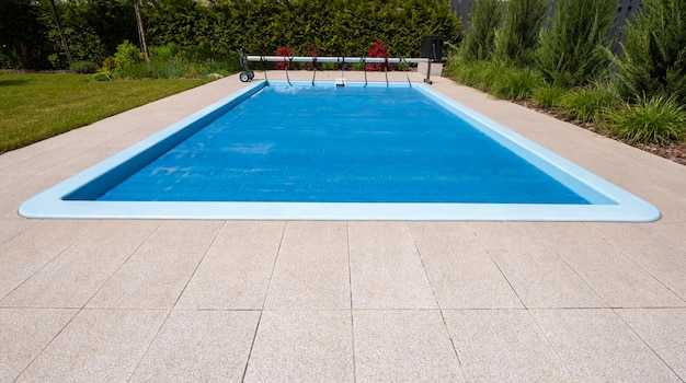 Foto piscina exterior doméstica coberta com filme para economizar produtos químicos, água e preservação do calor