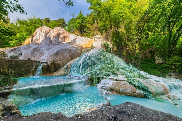 Foto piscina geotérmica e fonte termal na toscana itália bagni san filippo cachoeira termal natural pela manhã sem pessoas a baleia branca no meio da floresta