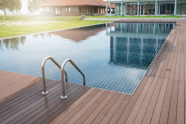 Piscina en el hotel con escalera y deck de madera en la playa