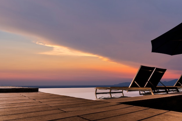 Piscina infinita de lujo con hamaca y terraza muy hermosa y relajarse con el cielo al atardecer