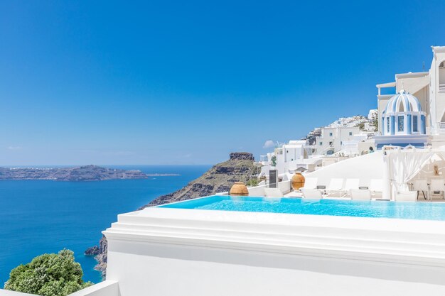 Piscina infinita con vistas a la caldera sobre el mar Egeo, Santorini, Grecia en un caluroso verano soleado