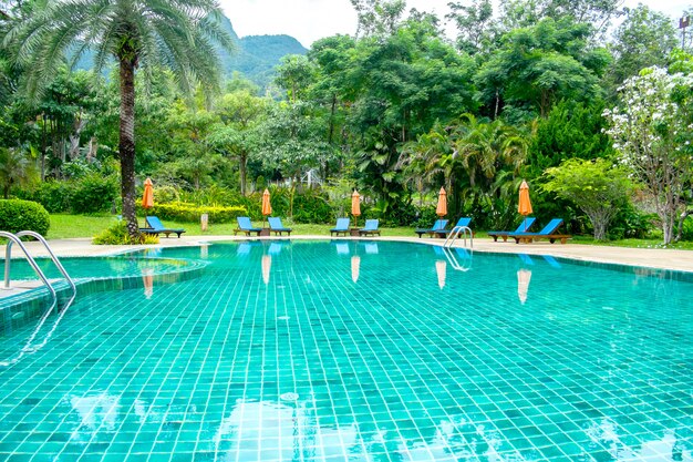 Piscina no resort tropical com cadeiras de praia