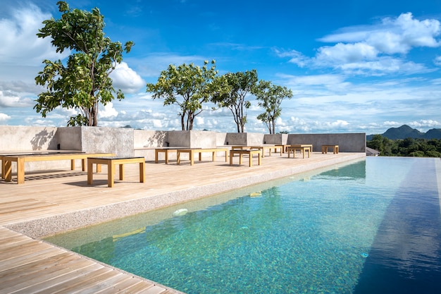 Piscina no topo do edifício da plataforma do telhado e reflexos ensolarados com piso de madeira teca listras férias de verão