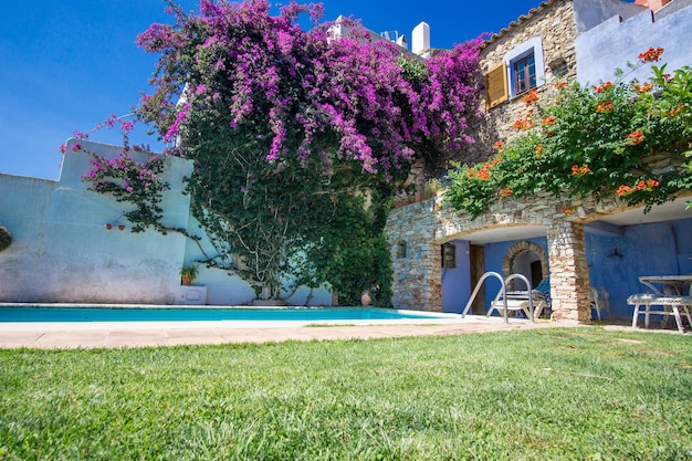 Piscina en el patio trasero de una casa de estilo mediterráneo en un día soleado